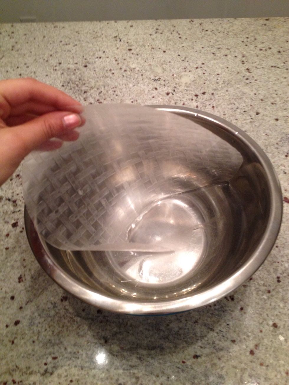 Soak the rice paper in warm water. Dont use boiling water because it will make the rice paper so soft it will stick to itself.  Leave it in warm water for about 15-20 sec or until it is soft.