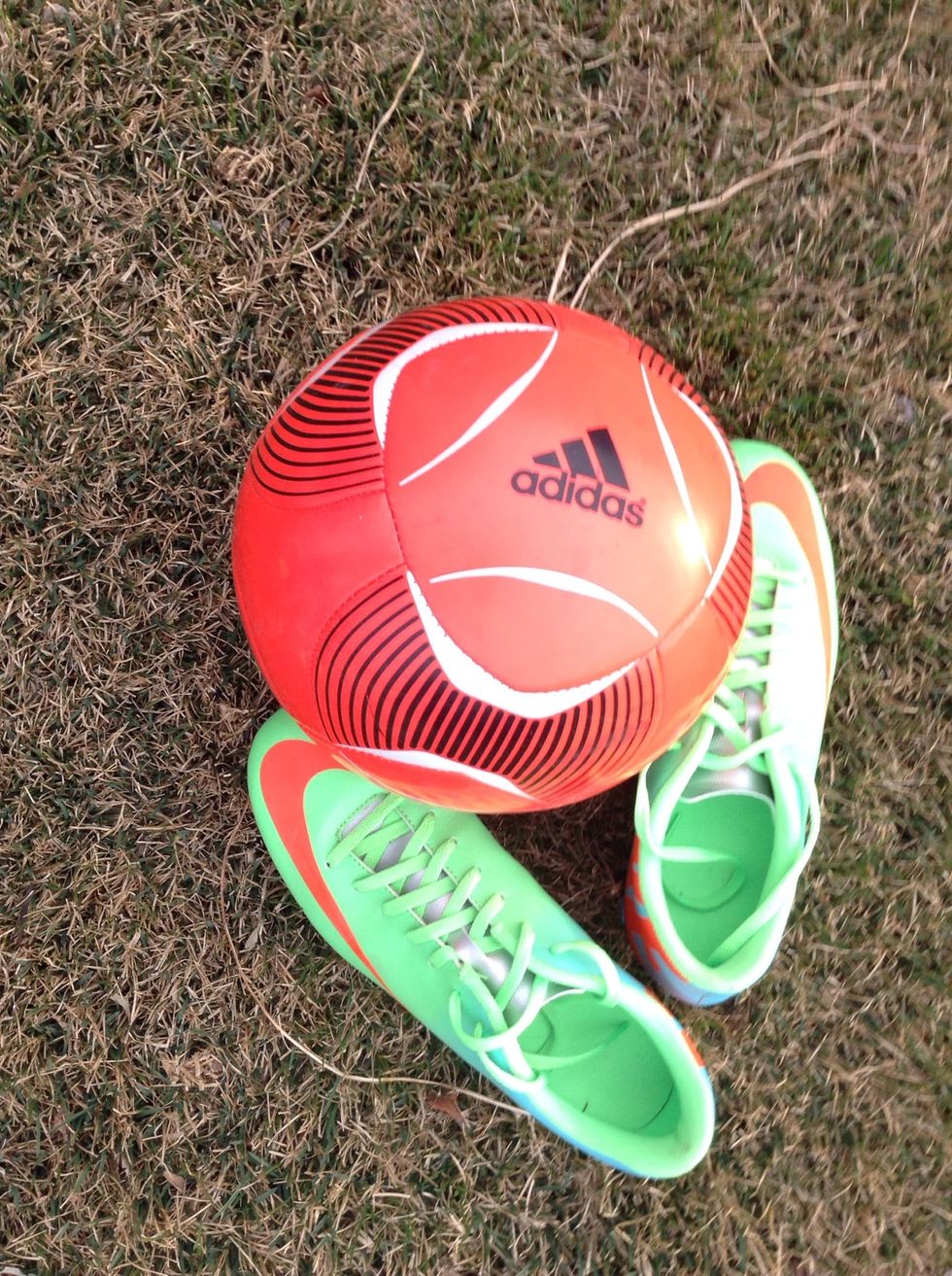 Soccer ball, shoes and a wide open area