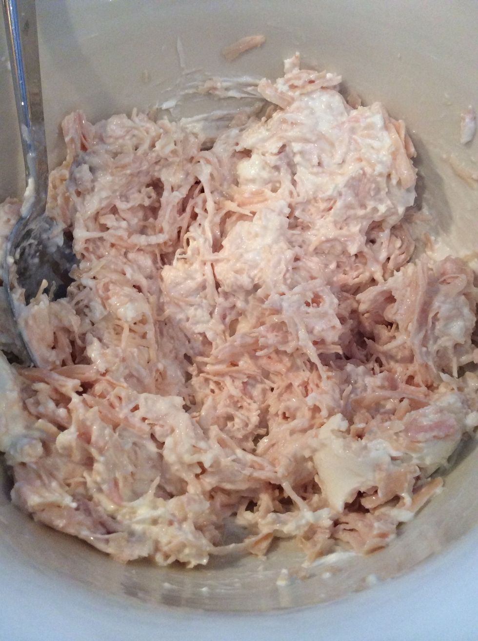Soften the cream cheese by mushing it with a spoon. Then add the chicken breast and mix well.
