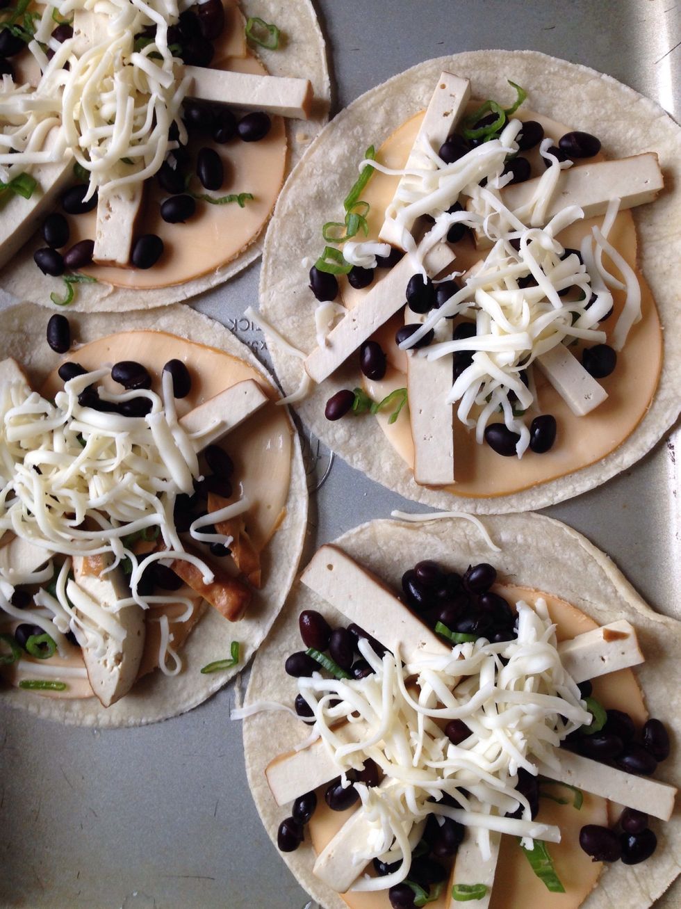 Some jack cheese. Yum! Now they are ready for the oven. Top each quesadilla with a tortilla and bake for 8 minutes on each side at 375 degrees and serve! I served them with a chipotle dip and sangria