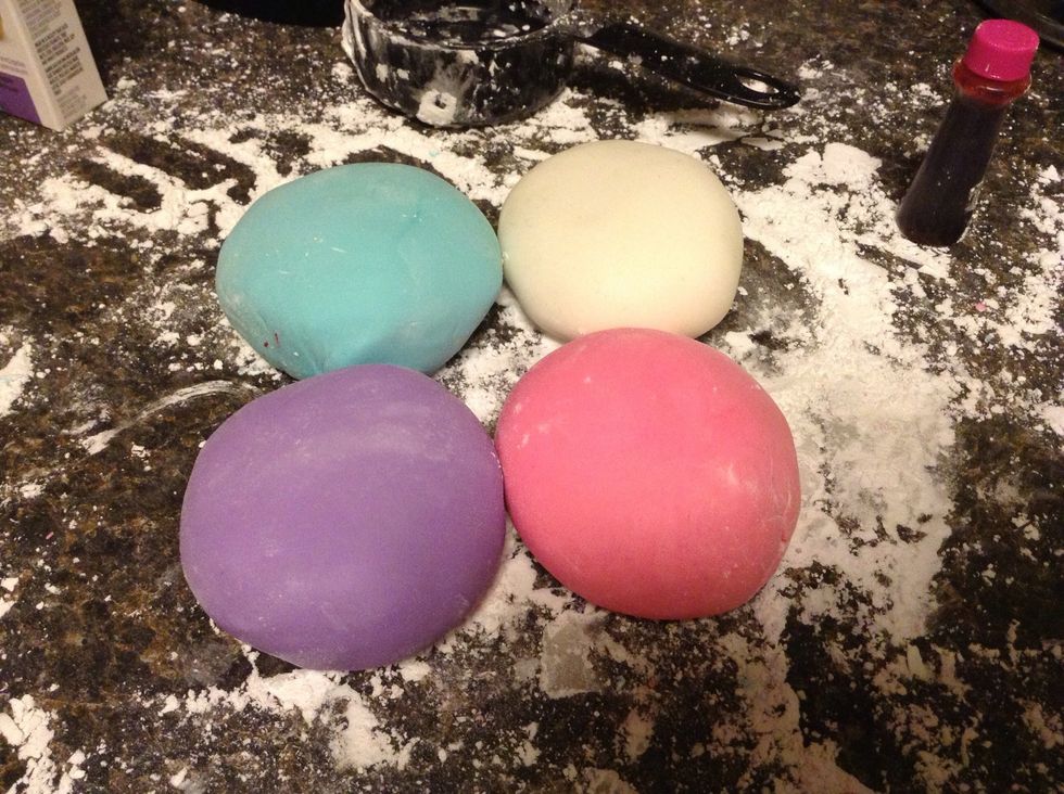 Soon you will have nicely colored fondant! If fondant is sticky, you may have added too much moisture from food coloring, so just put a tablespoon or two of powdered sugar and knead it out.