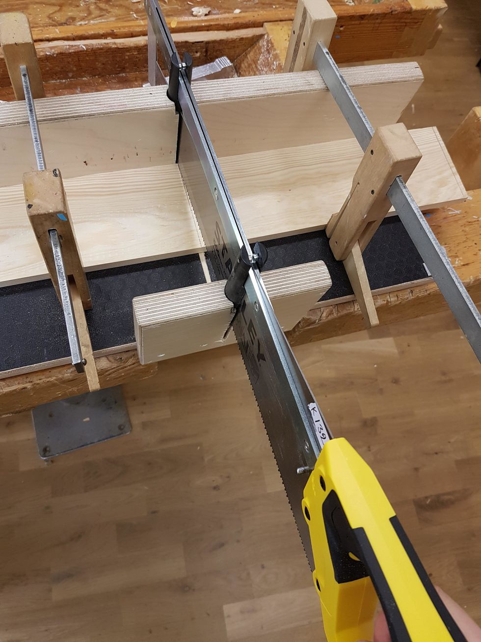 Sp\u00e4nn fast br\u00e4dan med limknektar. S\u00e4tt i s\u00e5gen och b\u00f6rja s\u00e5ga.