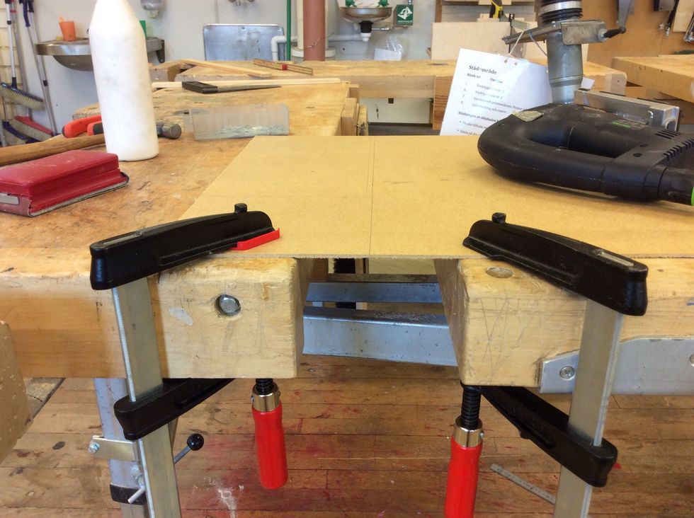 Sp\u00e4nn fast masoniten mellan b\u00e4nkarna, anv\u00e4nd skruvtvingar.