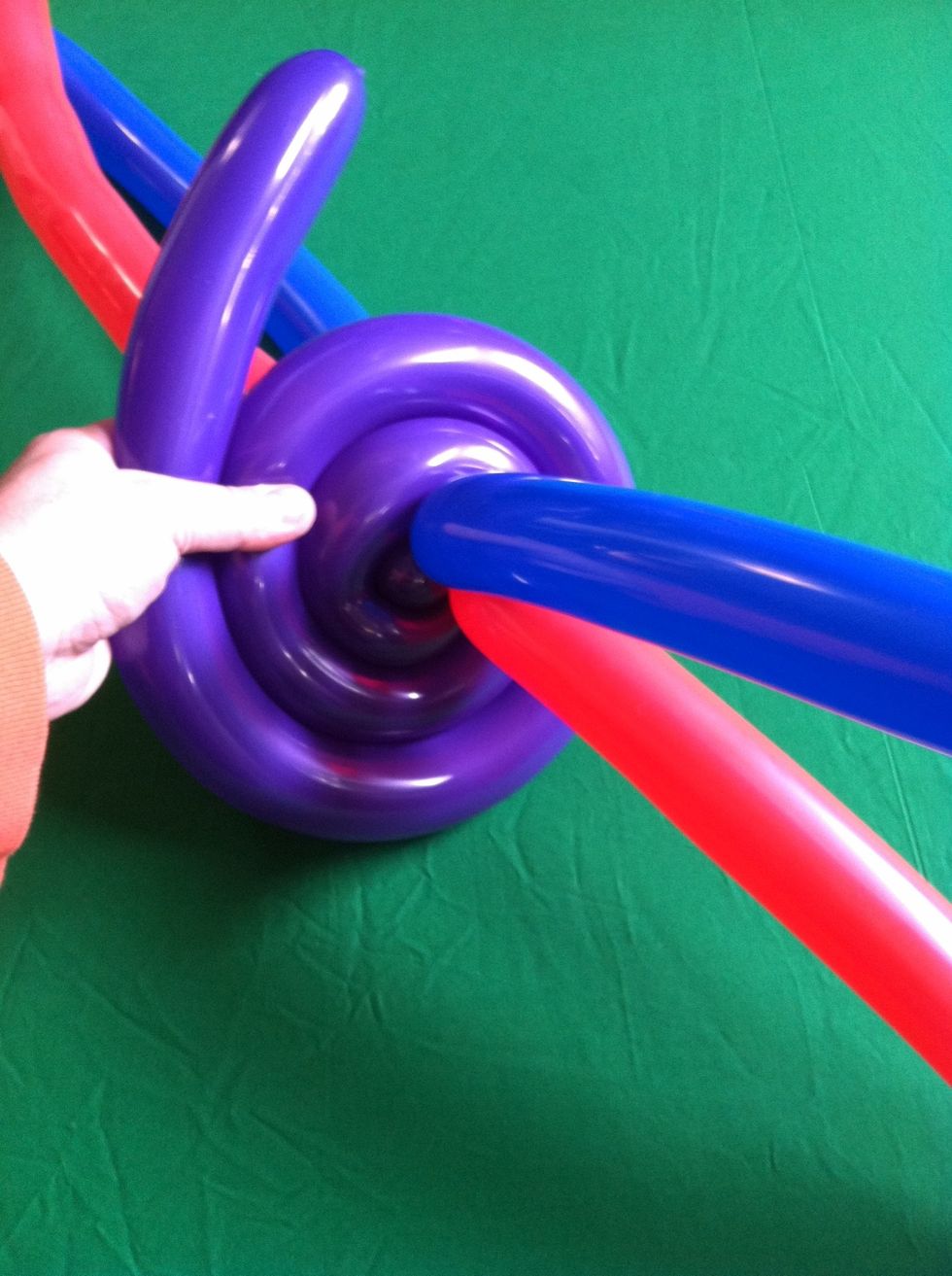 Spiral fifth balloon around the "x" keeping a constant pressure on the balloon as you spiral it