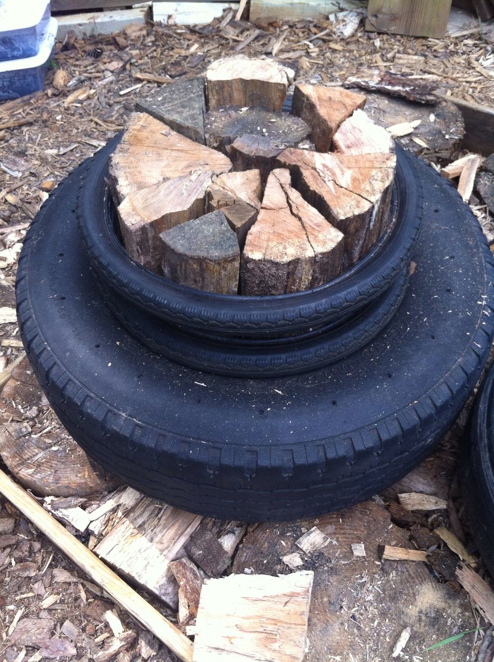 Split wood sawed into 1' long pieces is set tightly into the tire and then two bike tires are slipped around the protruding wood.. Avoid knotty pieces.