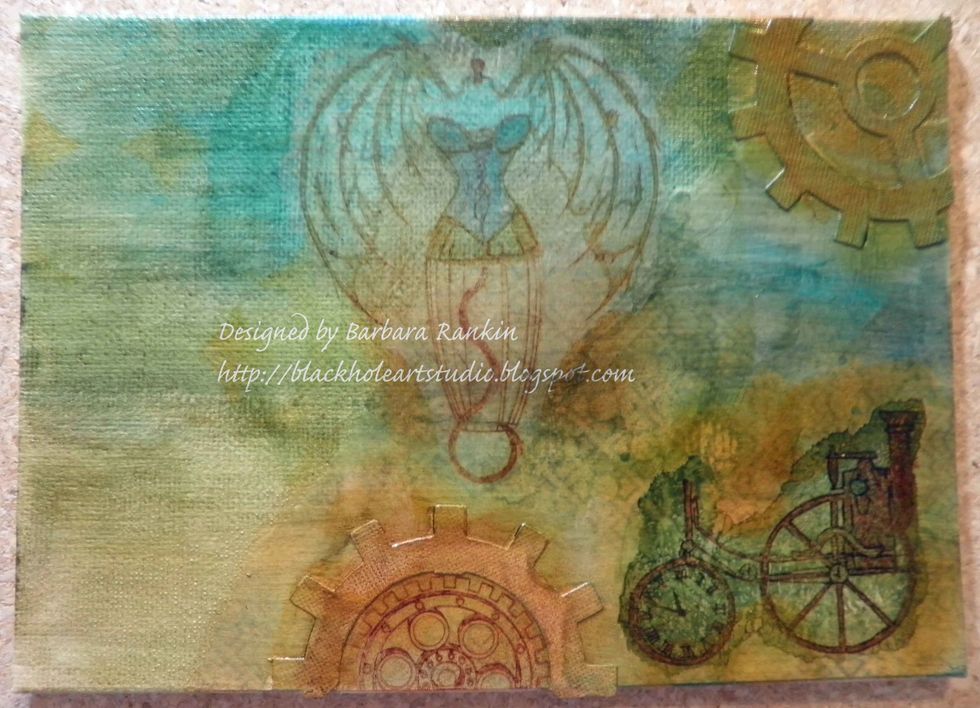 Sponge distress inks over canvas and die cut in Peacock Feathers, Rusty Hinge, Shabby Shutters, and Wild Honey. Sponge StazOn orange zest randomly over canvas gears and around steam engine.