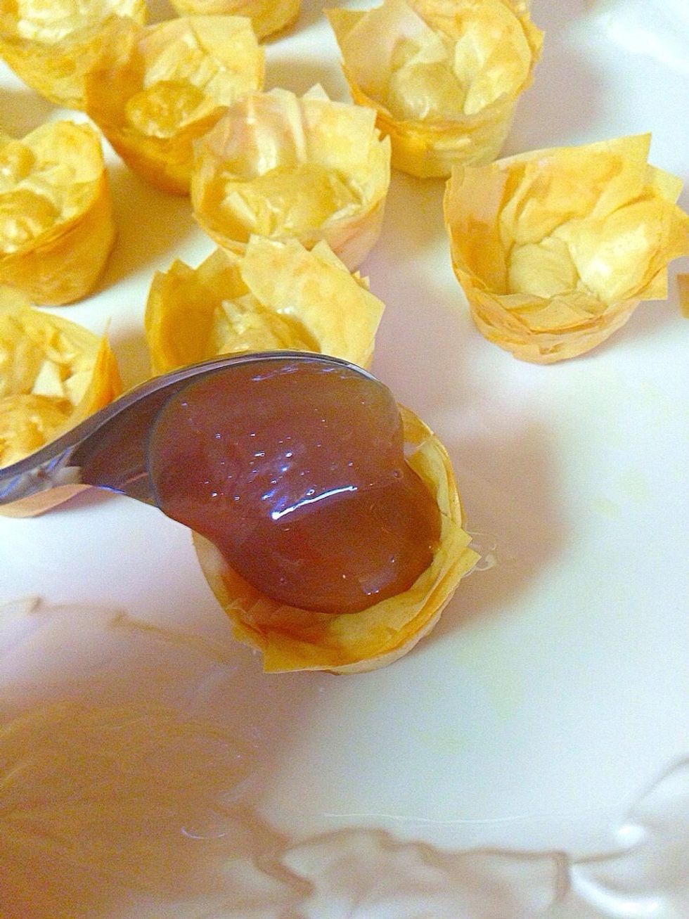 Spoon a dollop of dolce de leche into the phyllo cups