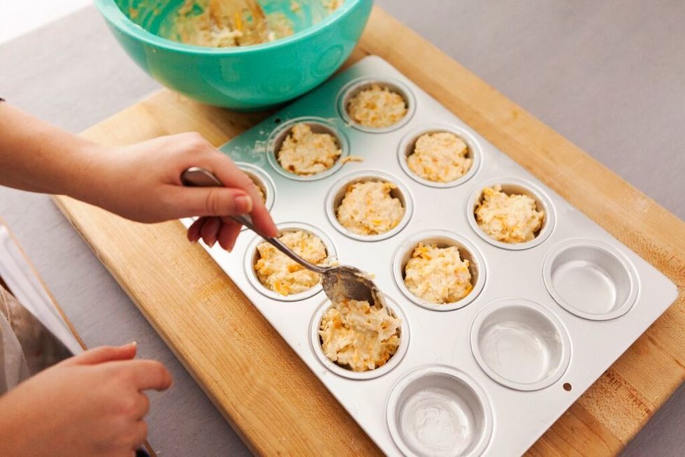 Spoon in batter. Make sure you have enough so that it fits equally in all 12 cups of the muffin pan.