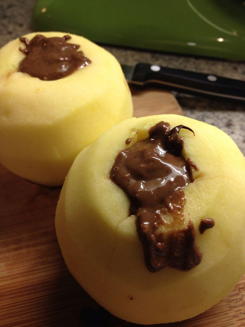 Spoon in your filling on one open end, then flip the apples over and spoon in some more until the apple centers are completely stuffed. Try not to get too messy!
