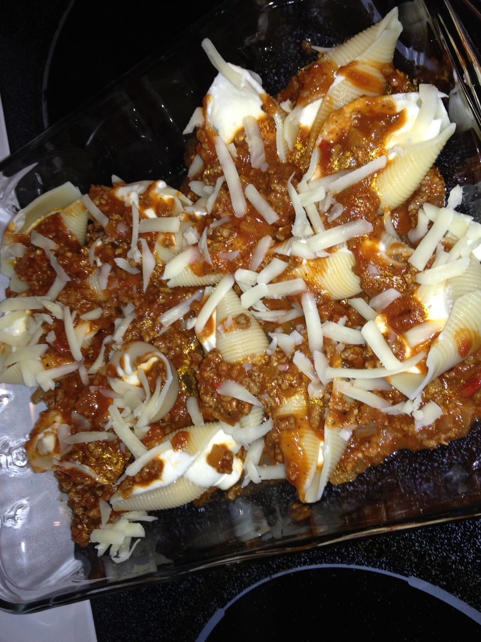 Spoon plenty of sauce and the mozzarella cheese that was set aside earlier onto the shells.
