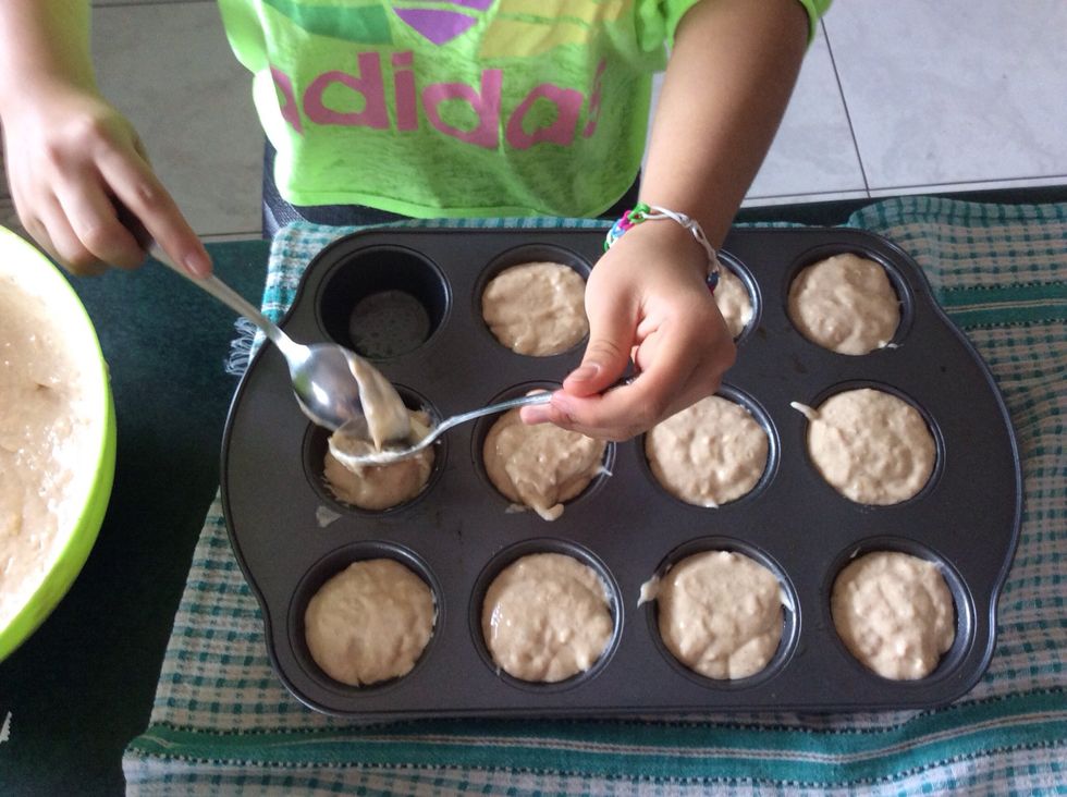 Spoon the mixture evenly into each hole of the muffin tin.