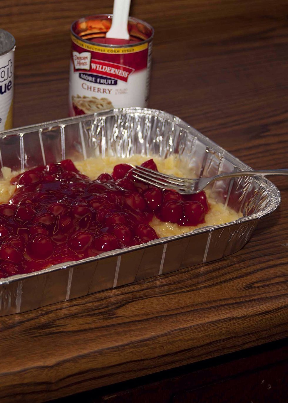 Spoon your cherries on top of the pineapples. Gently spread the cherries out. Get as close to the edges as you can. Be careful to keep the layers separate. I find that a fork works well for this.