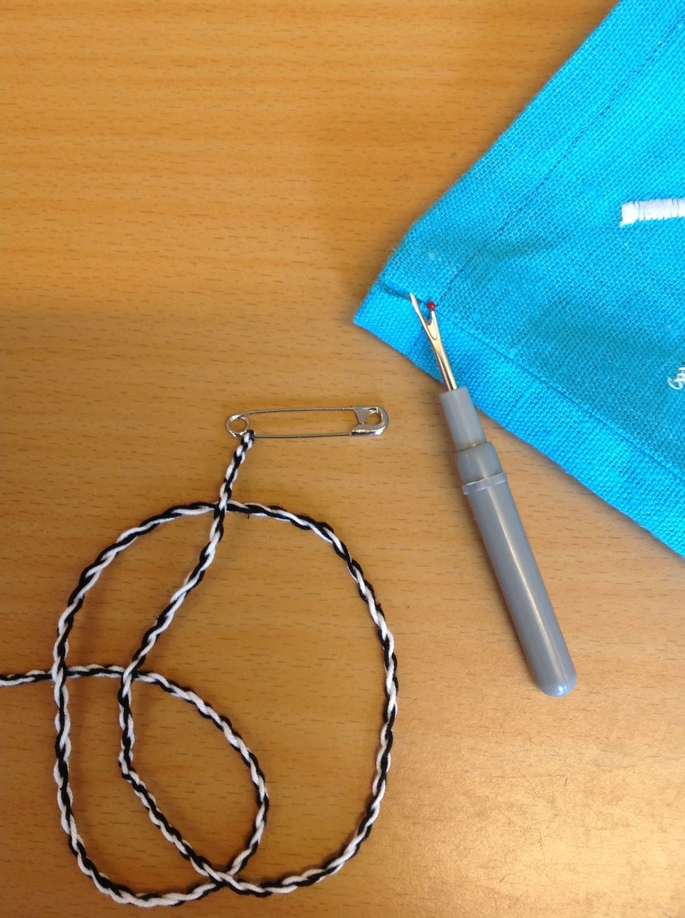 Spr\u00e4tt upp ett litet h\u00e5l i ena sids\u00f6mmen l\u00e4ngst upp (du kan f\u00e5 hj\u00e4lp med det.) G\u00f6r en snodd eller anv\u00e4nd ett band och tr\u00e4 in i kanalen.