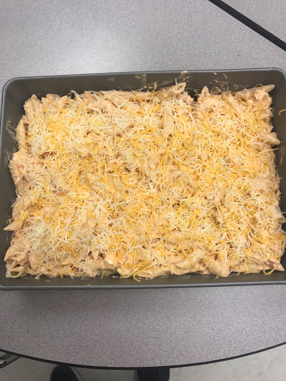 Spray 8-inch casserole dish with cooking spray Spoon in the noodle mix and spread evenly Take the remaining 1/2 cup of cheddar cheese and 1 cup of shredded mozzarella cheese and spread on top