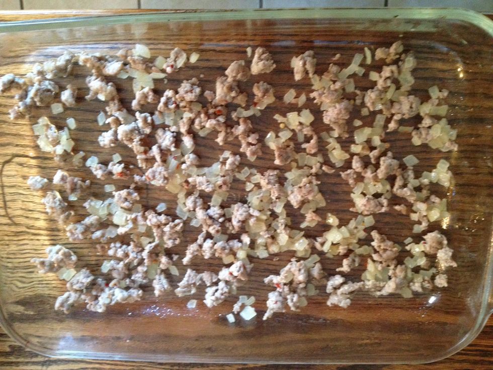 Spray a 13" x 9" glass baking dish with cooking spray, then layer your ingredients. I started with the cooled sausage and onions...