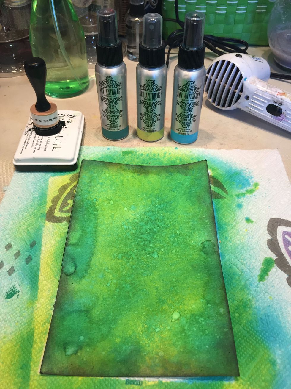 Spray a piece of watercolor paper with Peacock Feathers and Glorious Colorations. Dry. Spray with Waimea Bay and dry.  Spritz with water and then ink the edges with black ink.