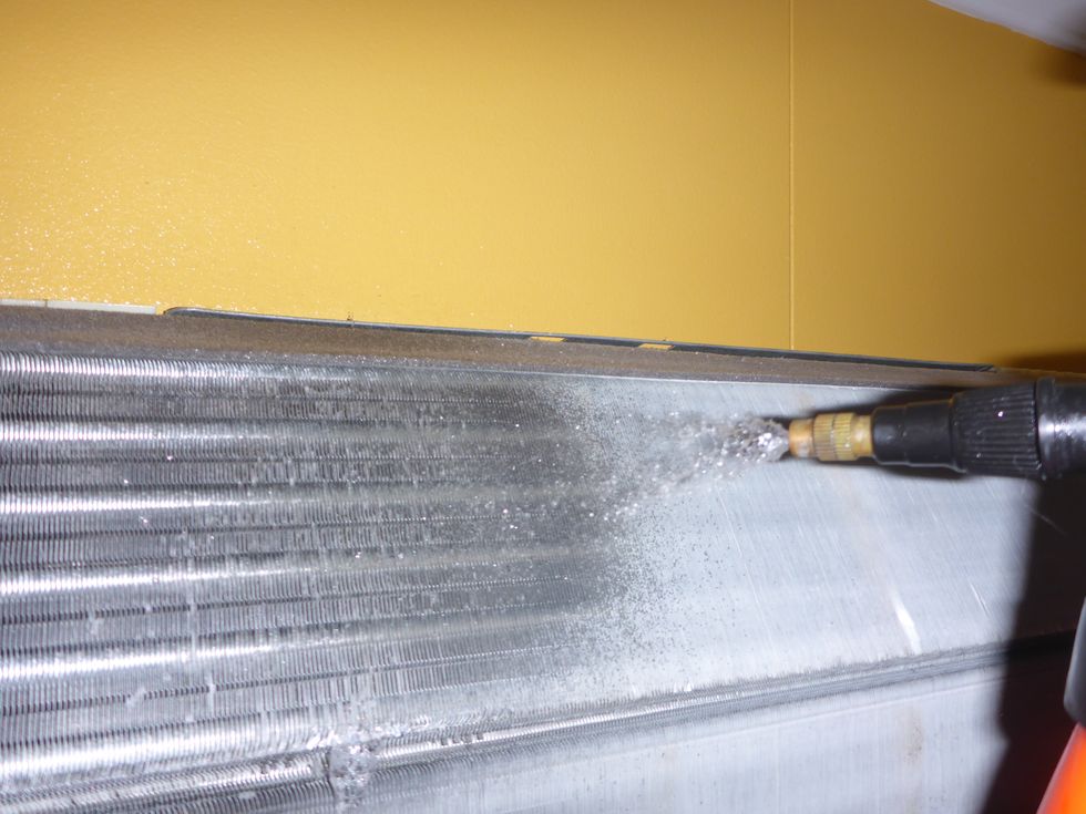 Spray all sides of the heat exchanger and let the solution sit for a few minutes. Rinse with warm water and repeat, then rinse untill most of the cleaning solution is gone from the drip pan.