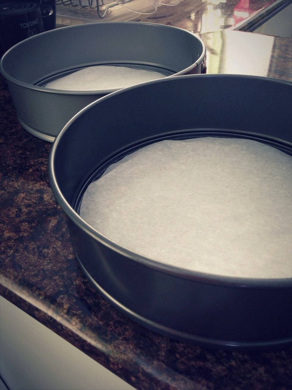 Spray and line the bottoms of two 9-inch pans with parchment paper.