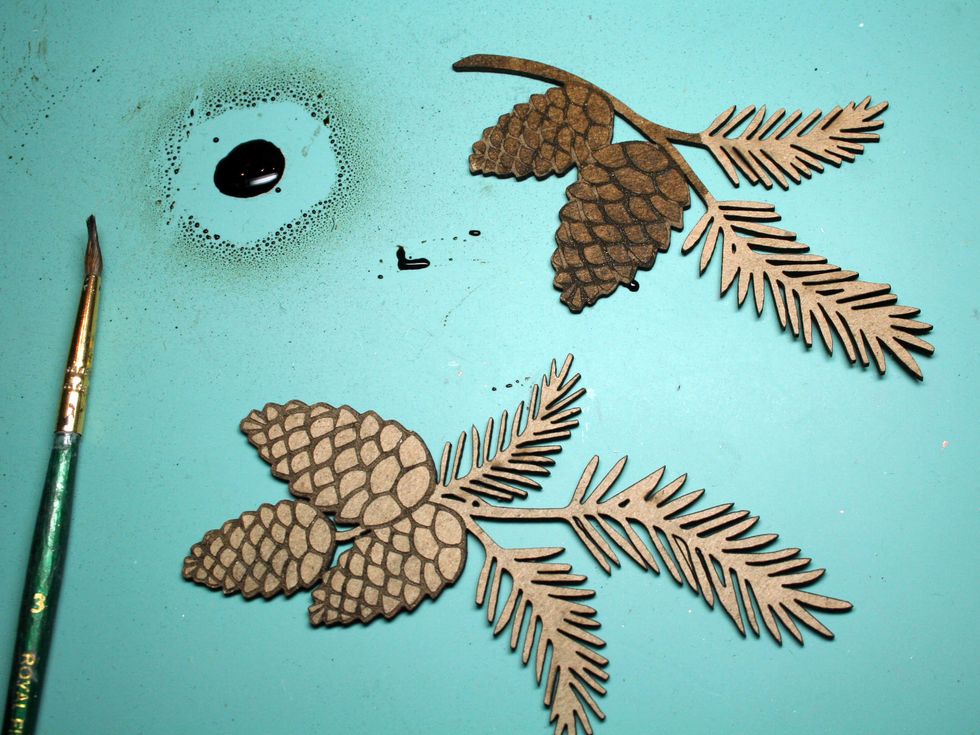 Spray some brown mist on your craft mat and paint it over the pine cones.  Using mist keeps the definition of the pine cone scales whereas paint tends to cover up these kind of laser etchings.