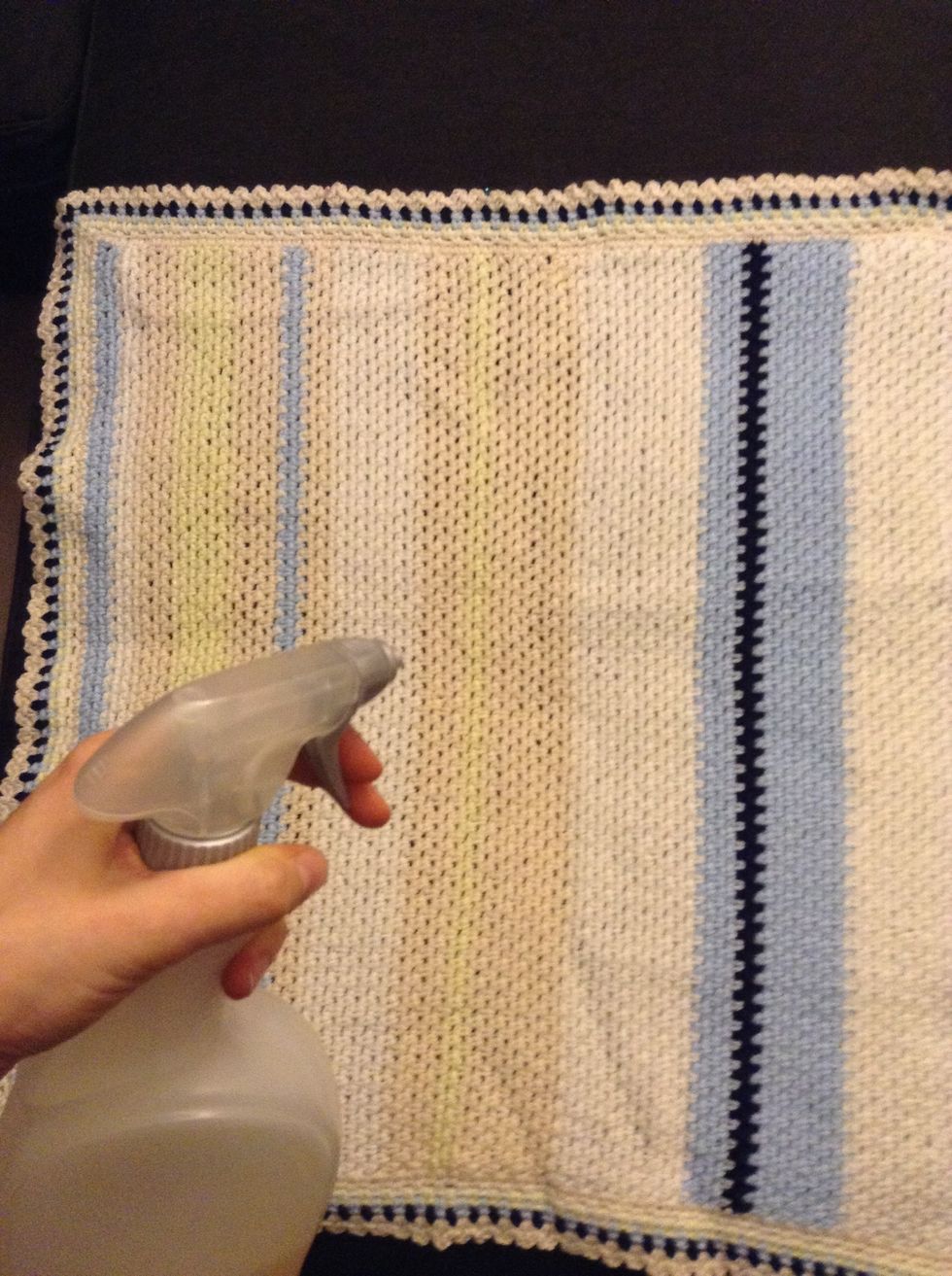 Spray the afghan with some water. Do not soak it too much just enough to make it malleable.