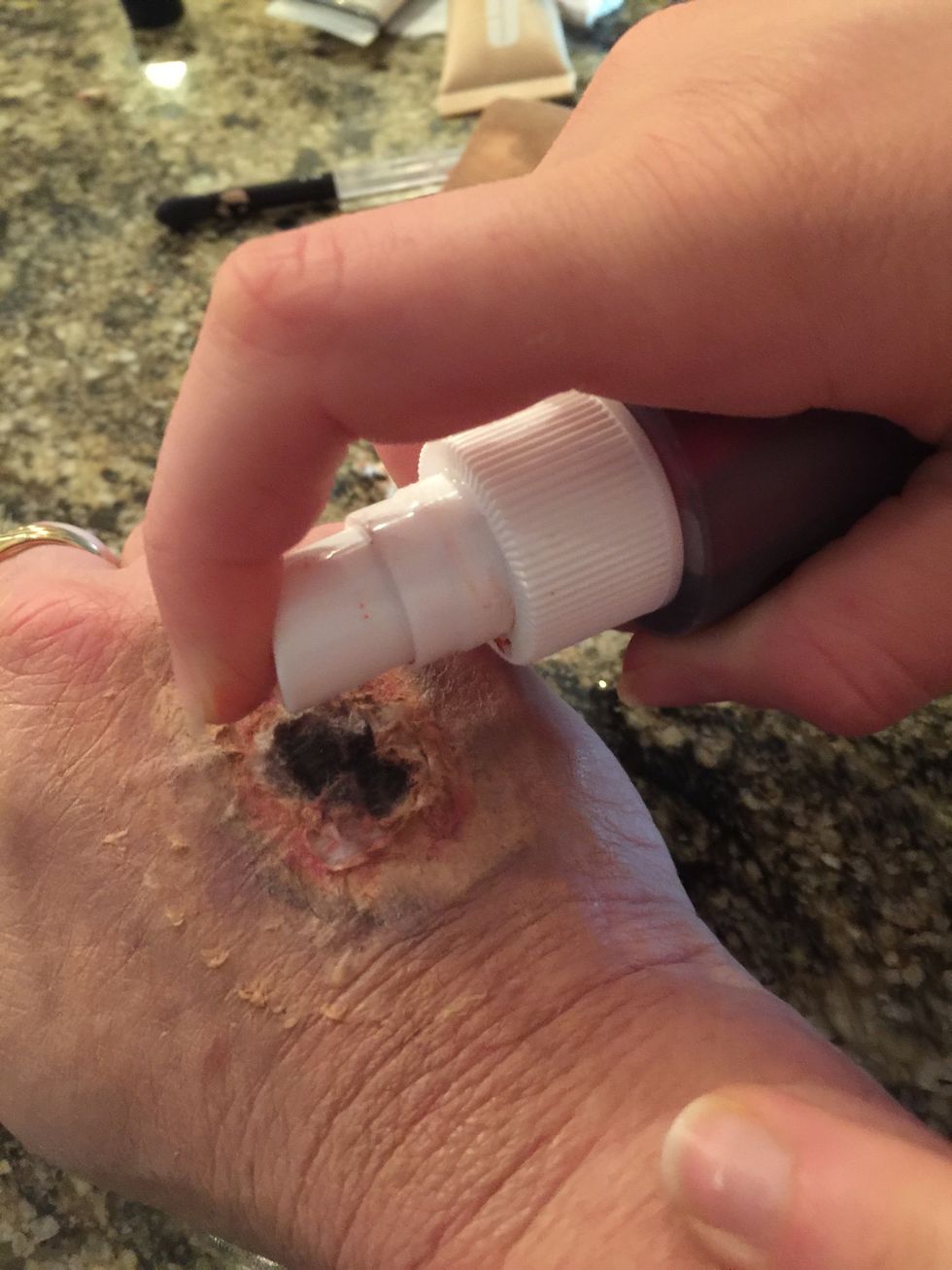 Spray the artificial blood, and spray it in the middle of the wound.