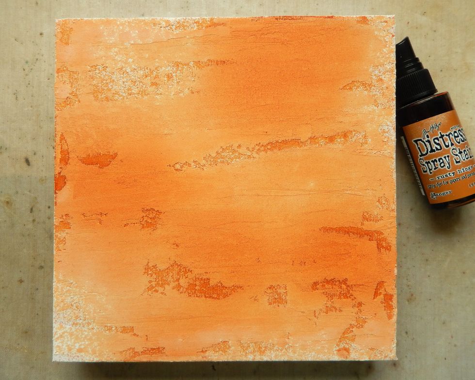 Spray the canvas with Rusty Hinge Distress Spray Stain avoiding complete coverage.