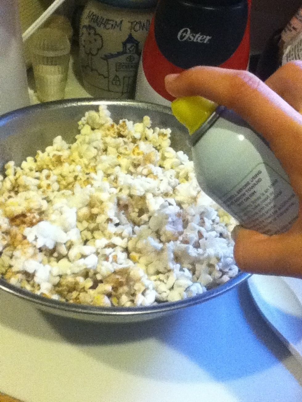Spray the popcorn with olive oil butter flavor spray