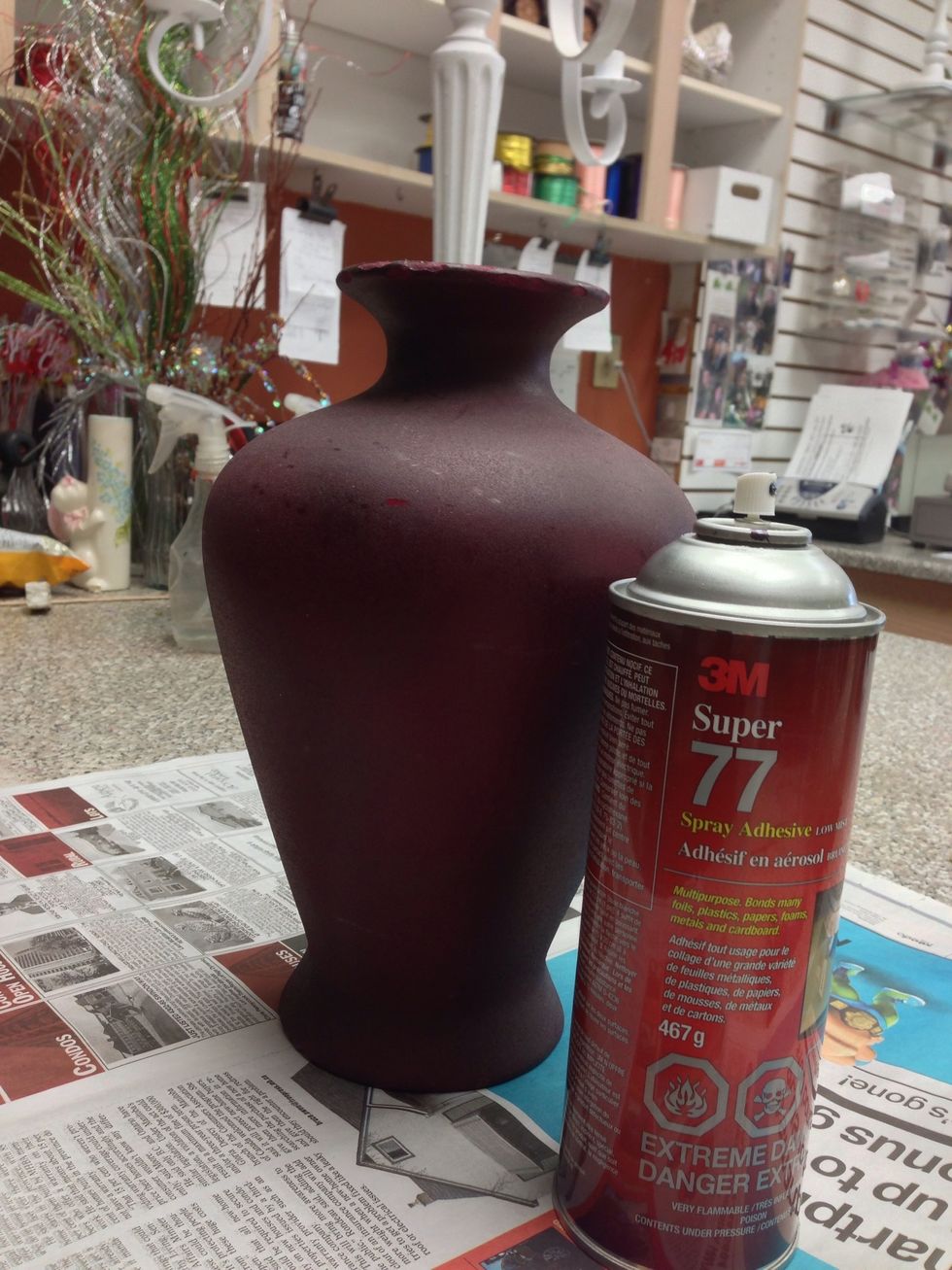 Spray the vase complexly with a spray glue. This will give a texture and allow the paint to adhere.