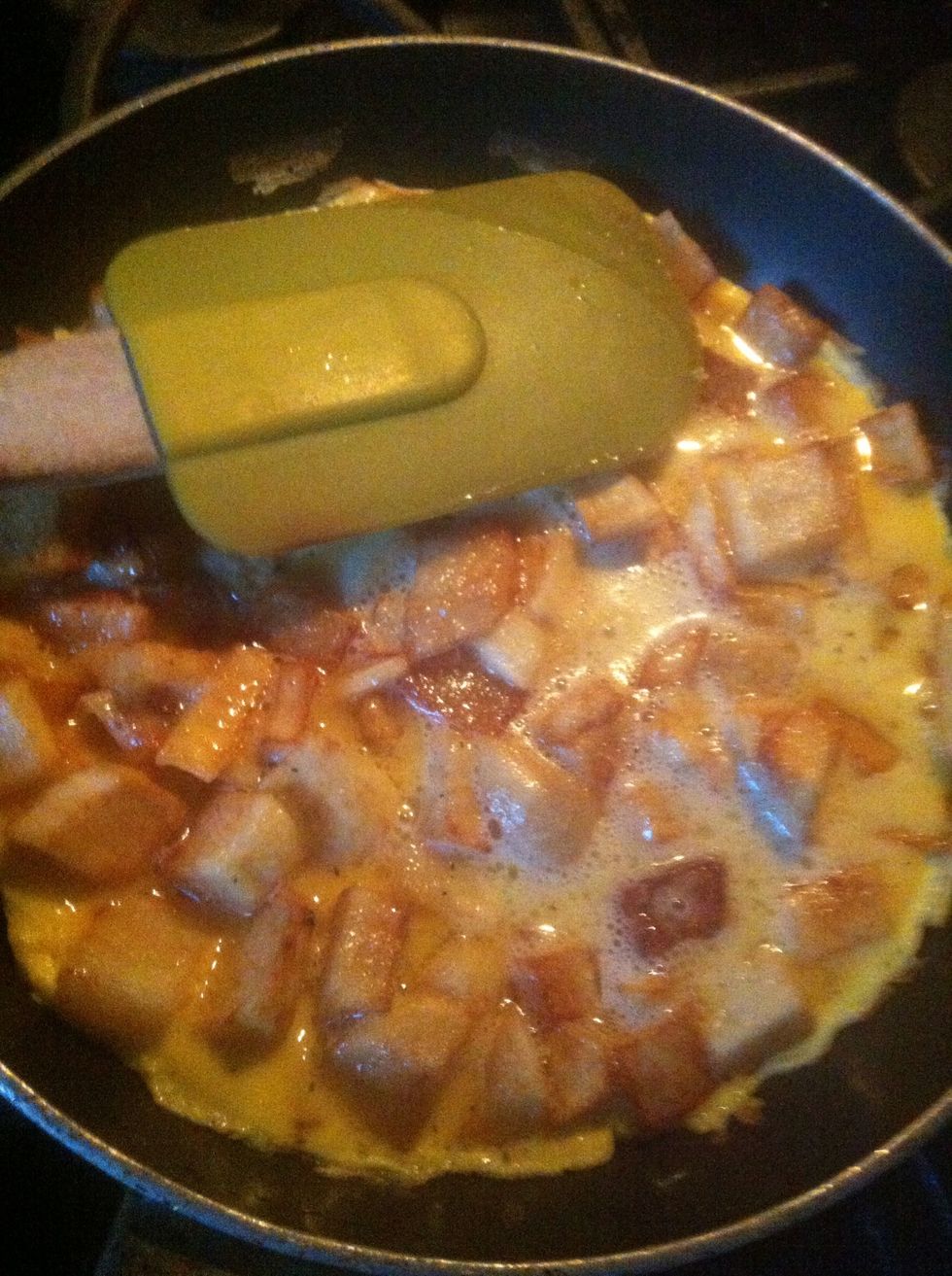 Spray your pan with cooking spray or put some butter on the bottom, add your potato chunks, and pour some egg mixture. The amount depends on the size of your pan.