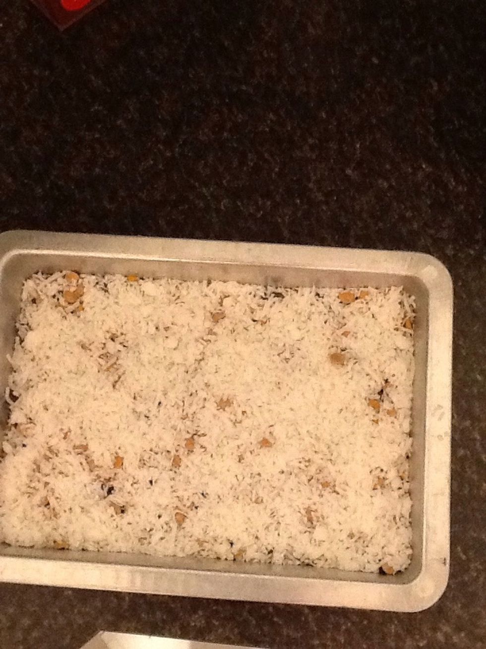 Spread 2 cups of coconut flakes in the pan and spread out.