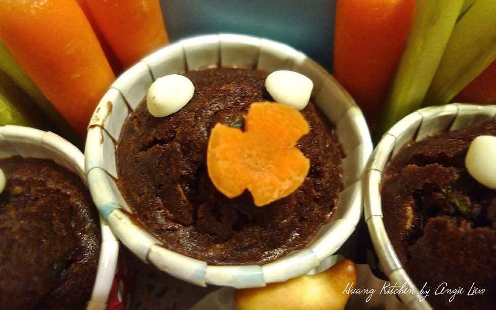 Spread a little Nutella on some white chocolate chips and carrot florets. Decorate on these muffins and they are ready for your kids school snack.