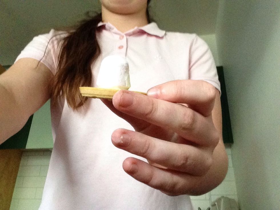 Spread a small bit of icing on the bottom of a marshmallow and stick it to a tic toc biscuit.