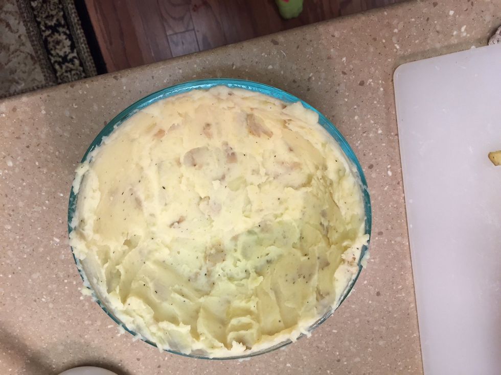 Spread a thick layer of potatoes over the inside of a glass baking bowl. Leaving enough space to stuff meat and top with more potatoes