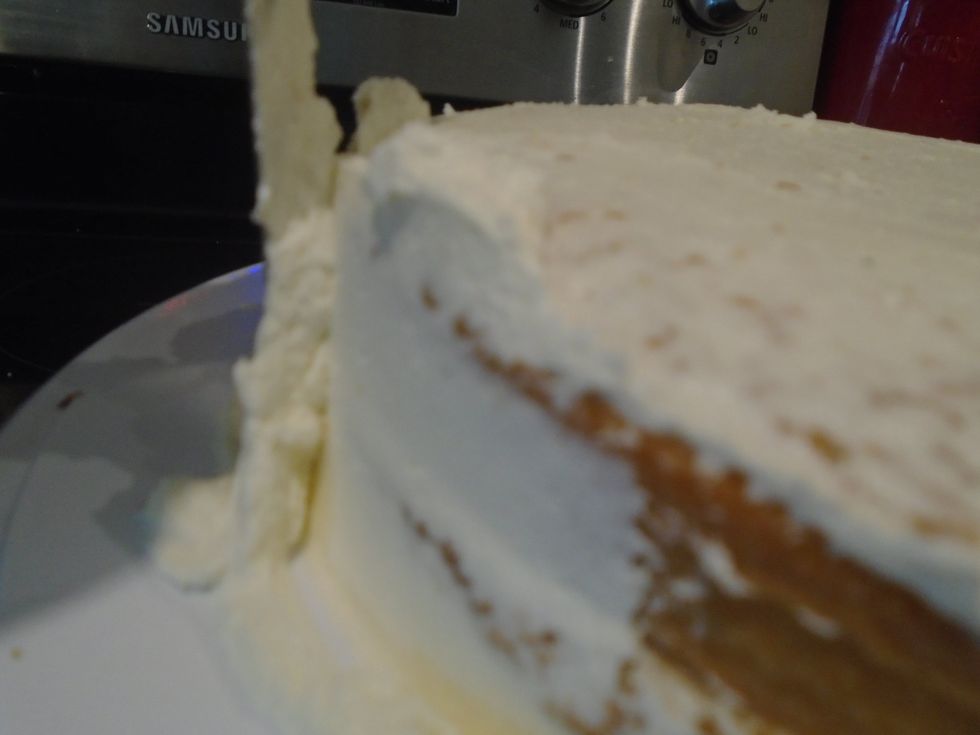 spread a thin layer of frosting on the sides with your offset spatula and place the cake in the fridge until you can touch the frosting and it doesn't stick to your finger.