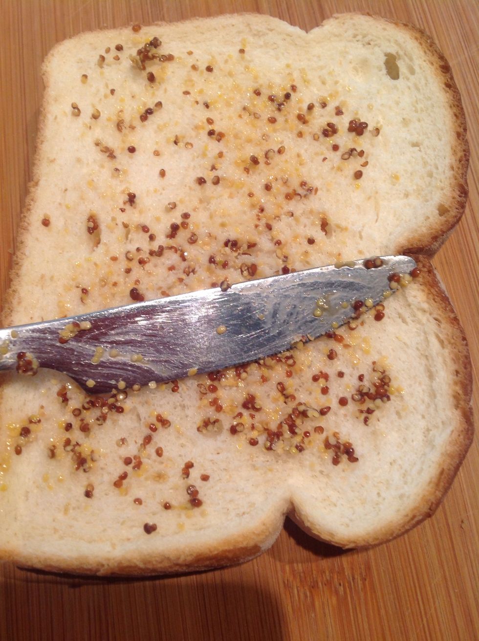 Spread a thin layer of mustard on one slice of bread