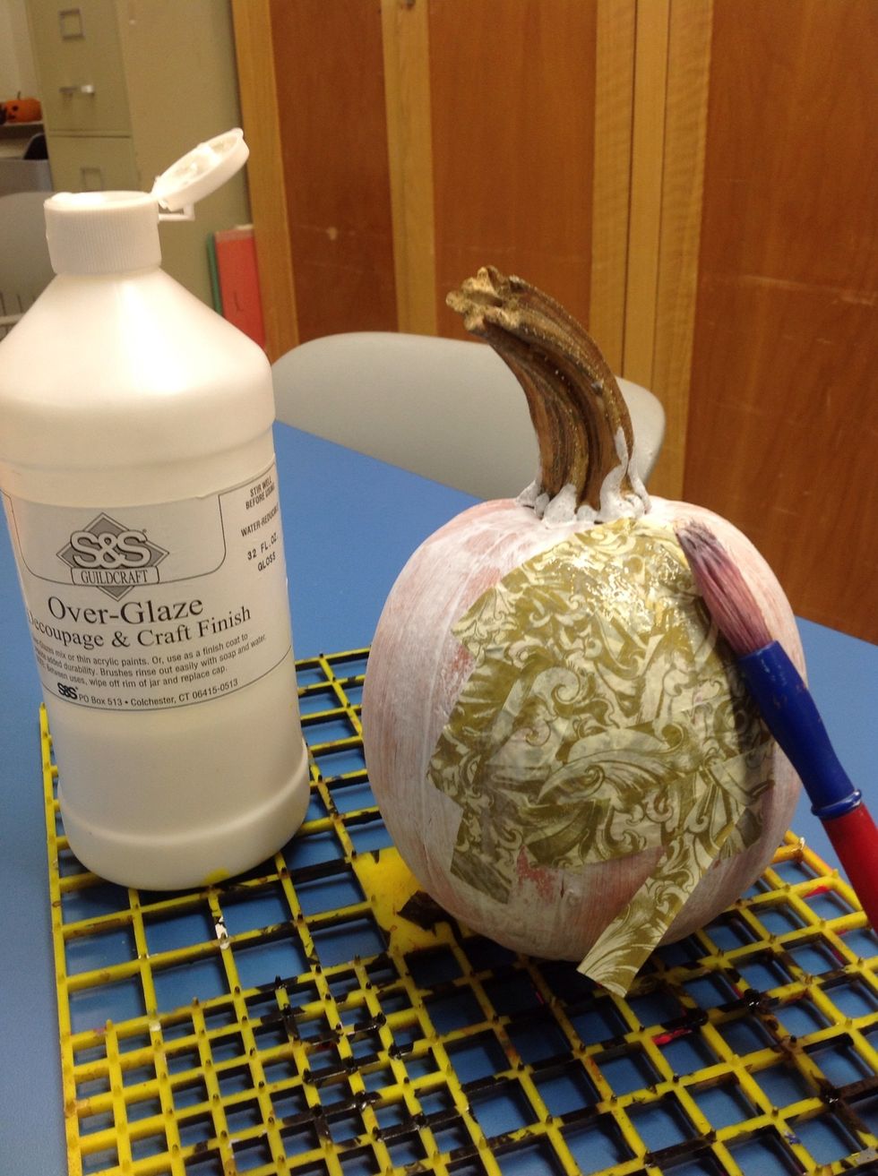 Spread a thin layer of over-glaze on the pumpkin and smooth tissue paper in an overlapping fashion.  Making sure to cover the entire pumpkin.