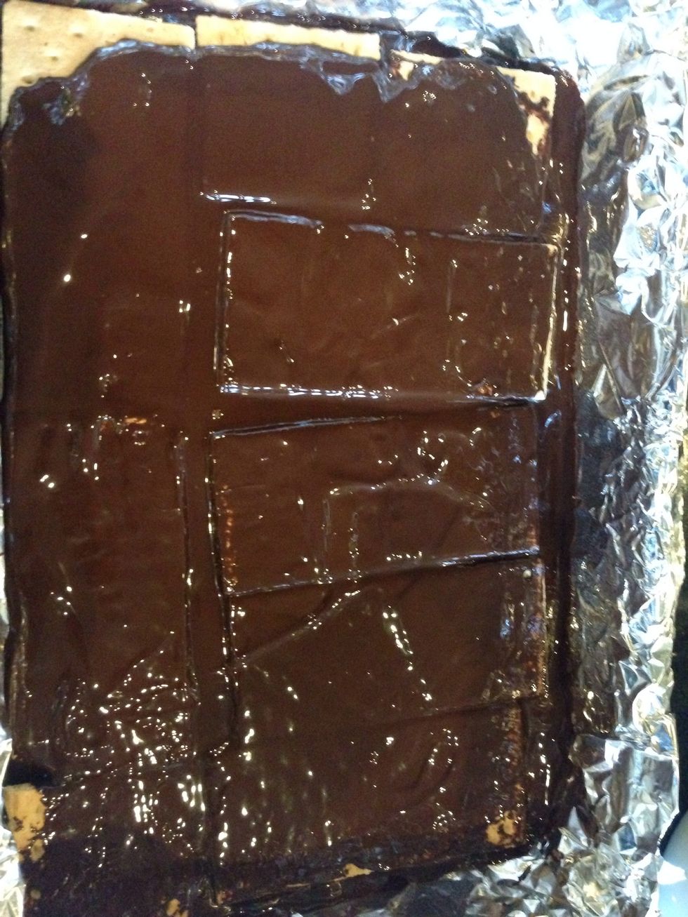 Spread chocolate across crackers.