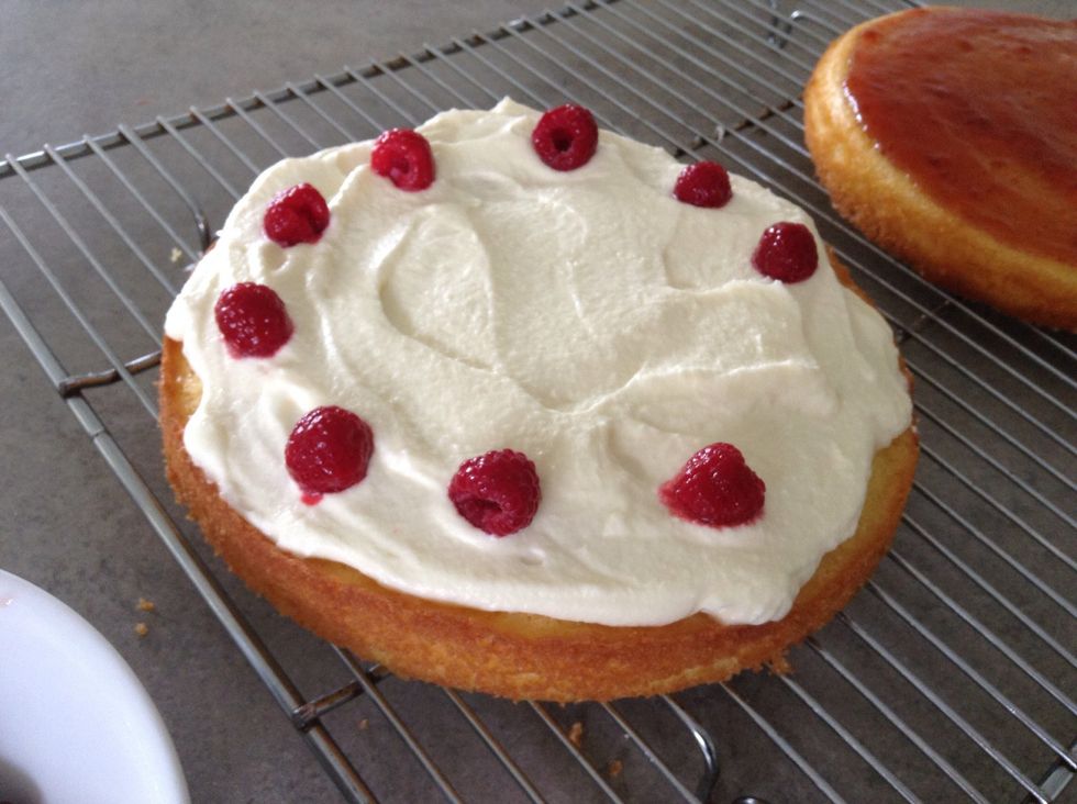 Spread cream over the top of the other cake and decorate with raspberries