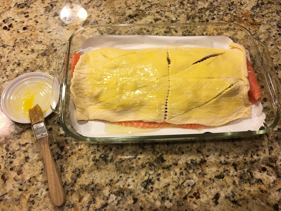 Spread egg yolk on the crescent roll using a pastry brush.