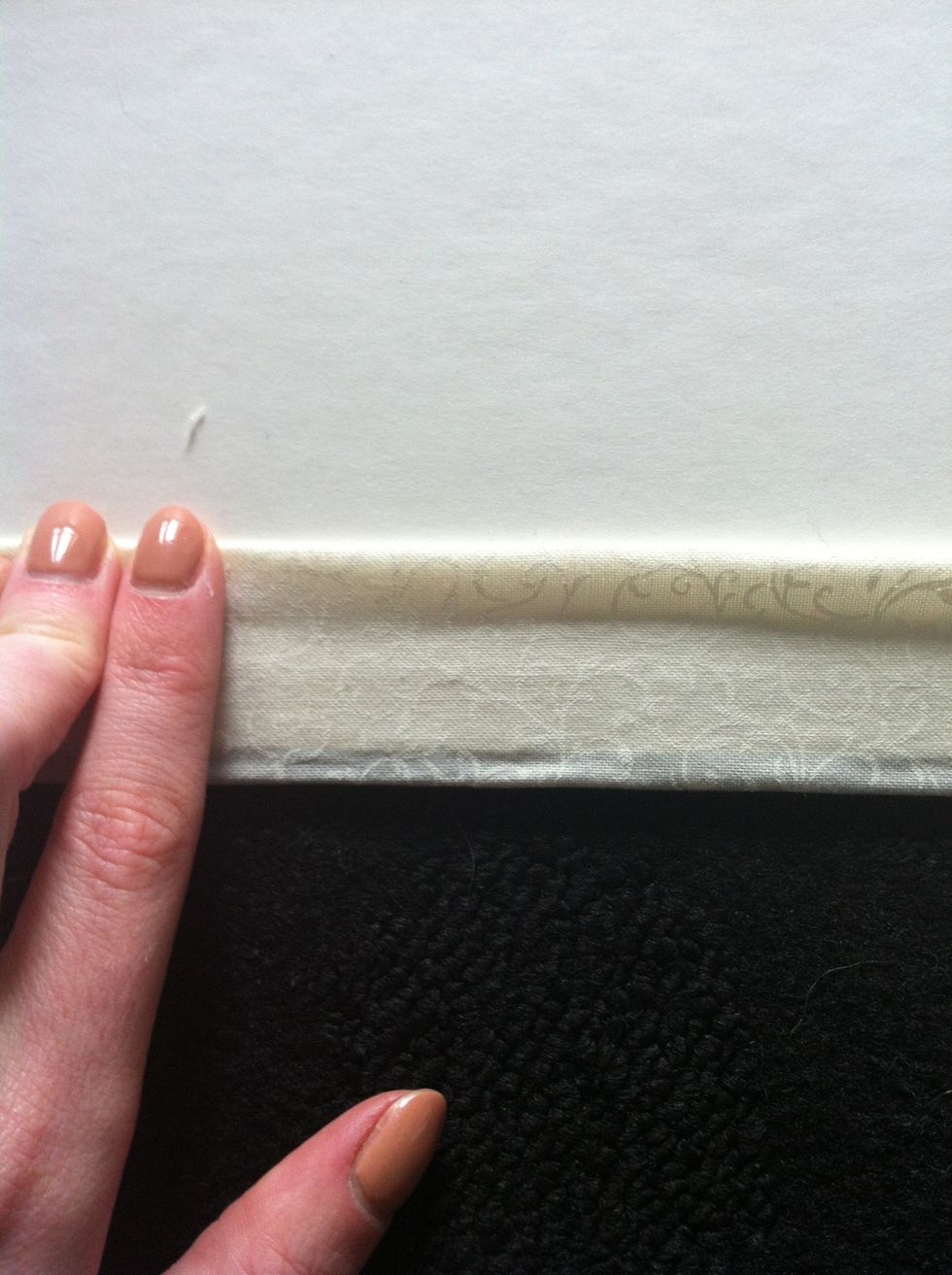 Spread glue down the book edge and fold over the end of material so it is a straight edge
