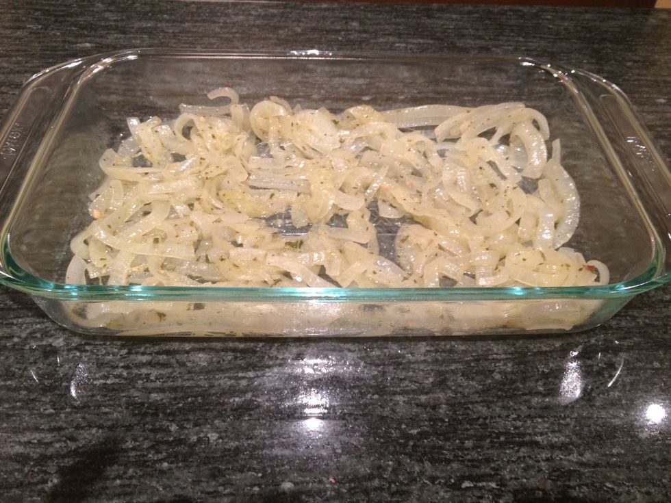 Spread half of the onions on the bottom of a baking dish.