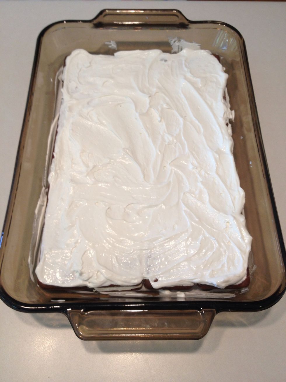 Spread half of the whipped cream container on top of the sandwiches. If you like, you can sprinkle some Oreos on top of this layer.