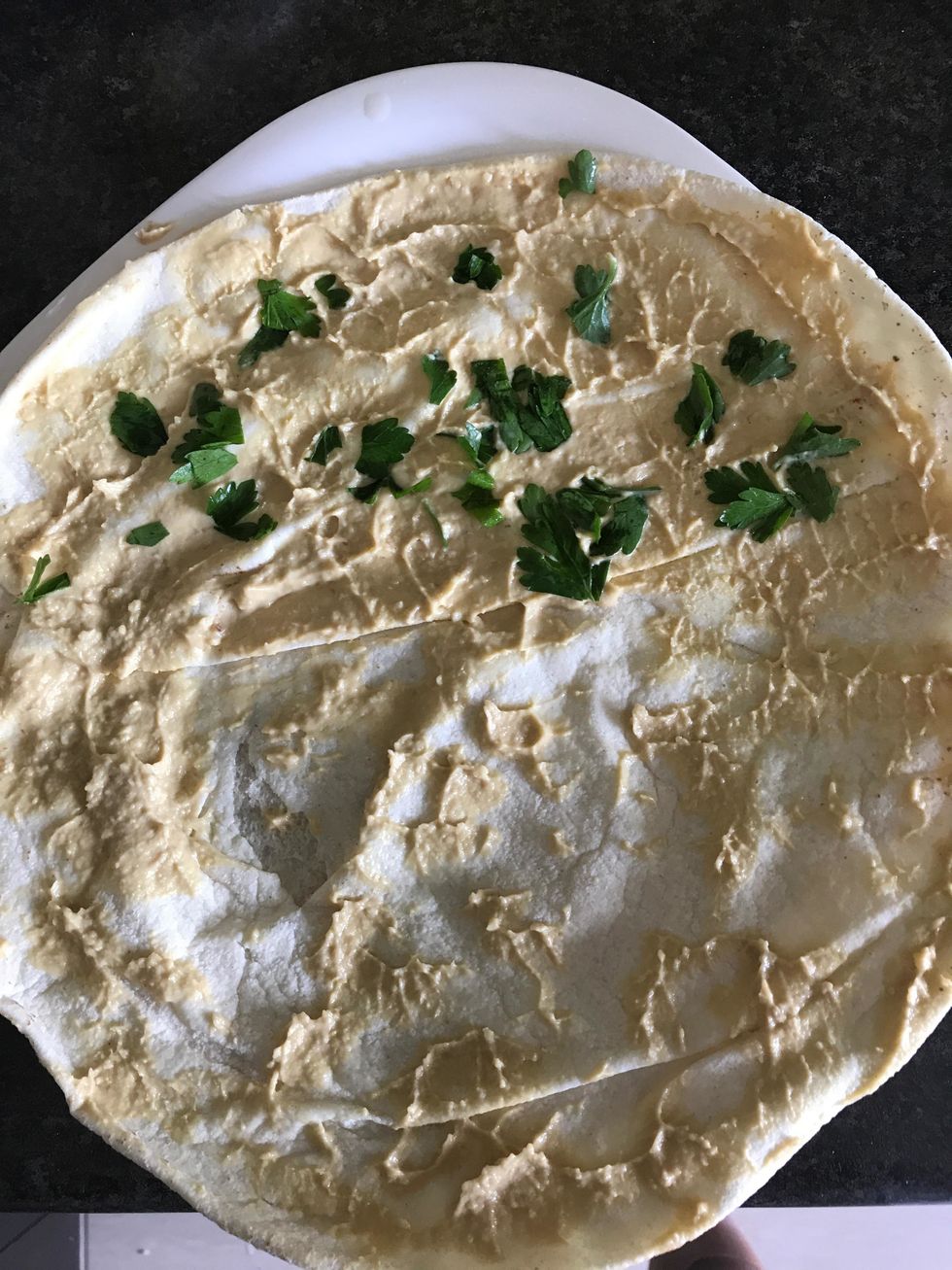 Spread hummus generously over your tortilla. Lightly cover one-half of the tortilla with fillings of your choice. Fold the blank half over to create a half-moon shape