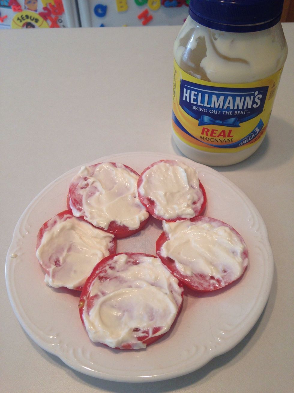 Spread mayo on each tomato.