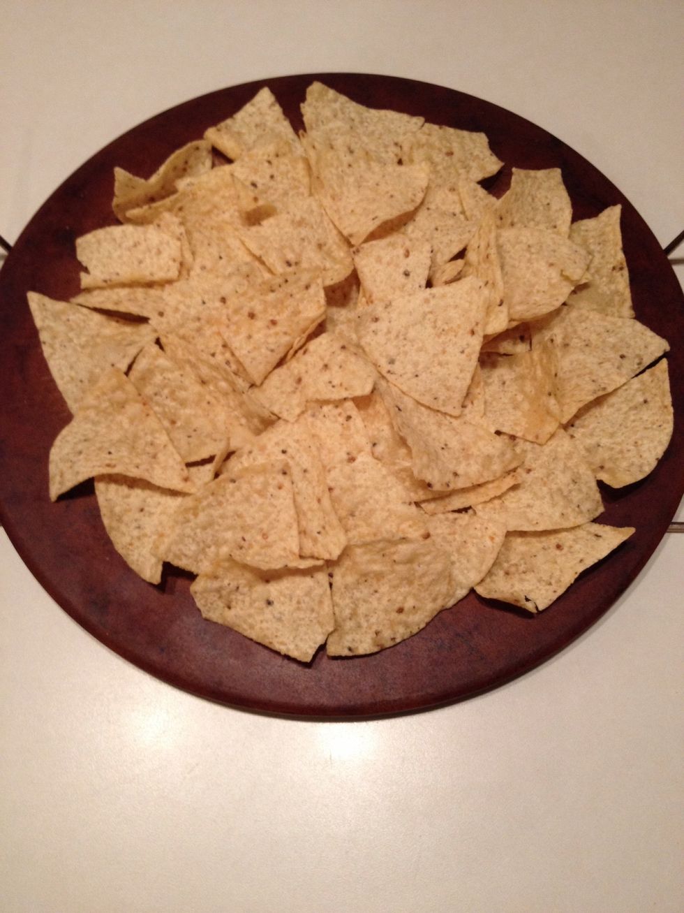 Spread nacho chips across a platter that can go in the oven.