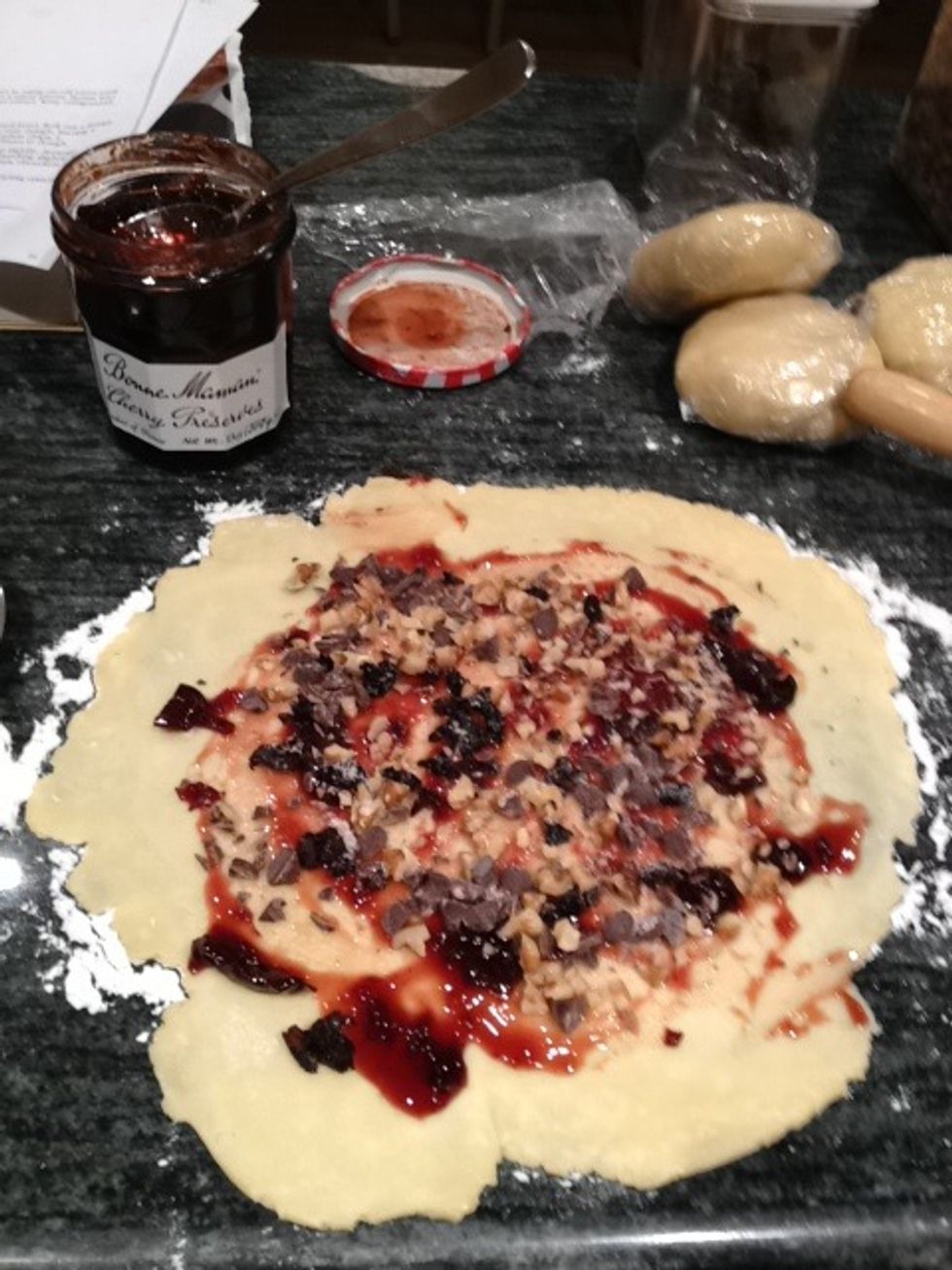 Spread on the preserves first, then sprinkle on the nuts, dried cherries, and chocolate (2 tablespoons each). If you like your rugelach to be very sweet, add a sprinkling of sugar.