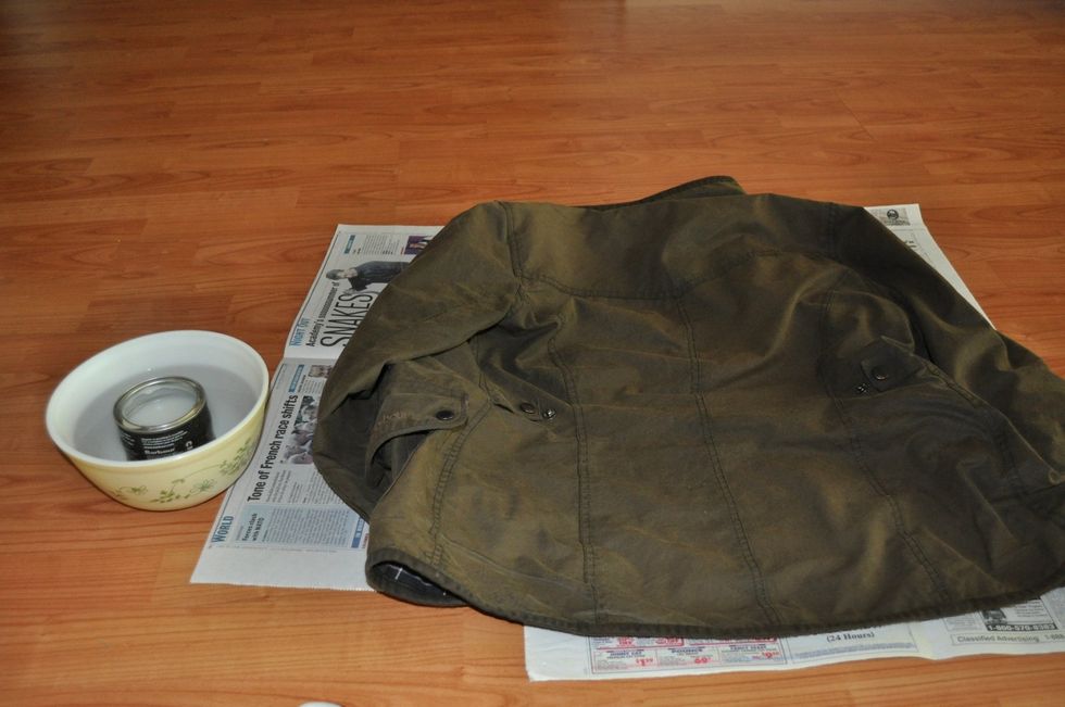 Spread out the newspaper and lay the jacket on it as flat as possible.