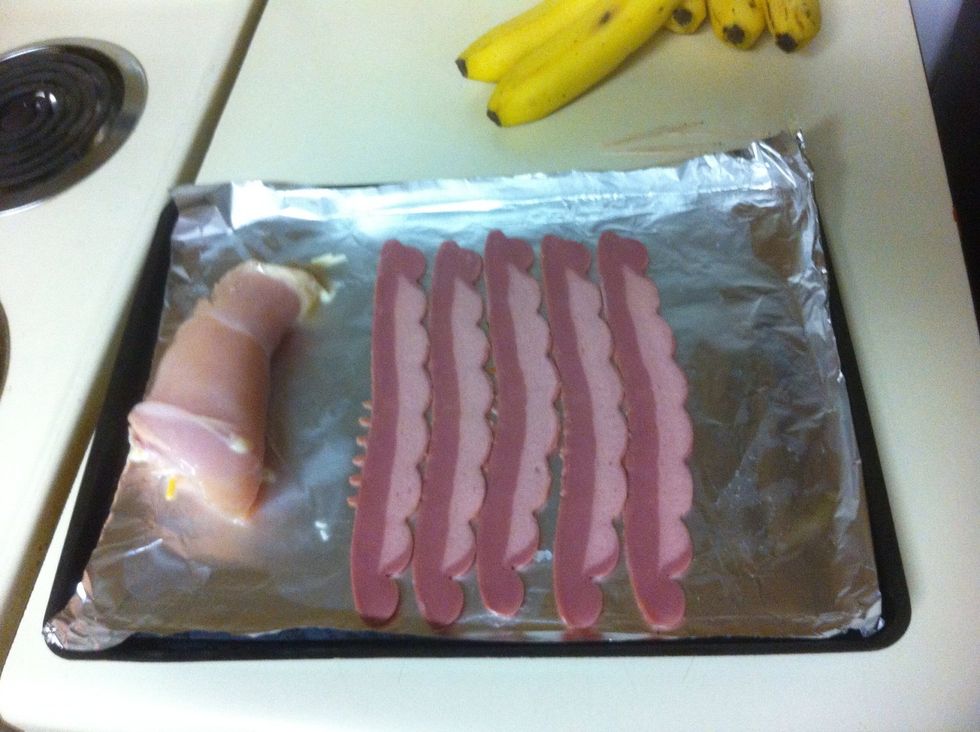 Spread out the (turkey) bacon and wrap up the chicken inside it. Alternatively you can do this step with the previous one if that is easier. Use bacon generously.