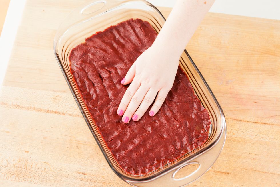 Spread out your red velvet cake batter. You can do this with a spatula or your finger to ensure it's evenly spread out. Then, bake for 20-22 minutes.