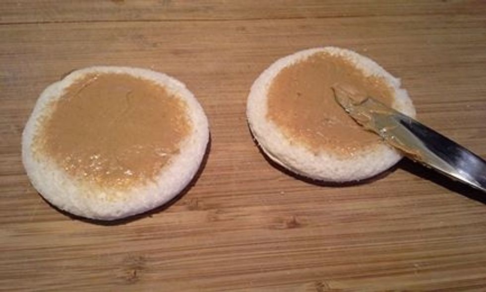 Spread peanut butter onto bread.  Do not go to the edge, the bread will not seal properly.